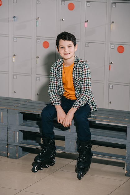 Cute brunette boy in checkered shirt posing in roller skates