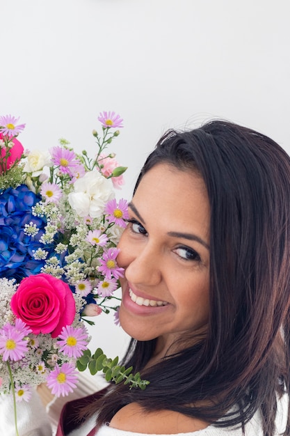 Cute brunette woman enjoying her bouquet of flowers