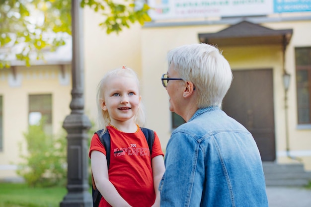 Cute caucasian blonde little girl going to school Mother having a conversation with child