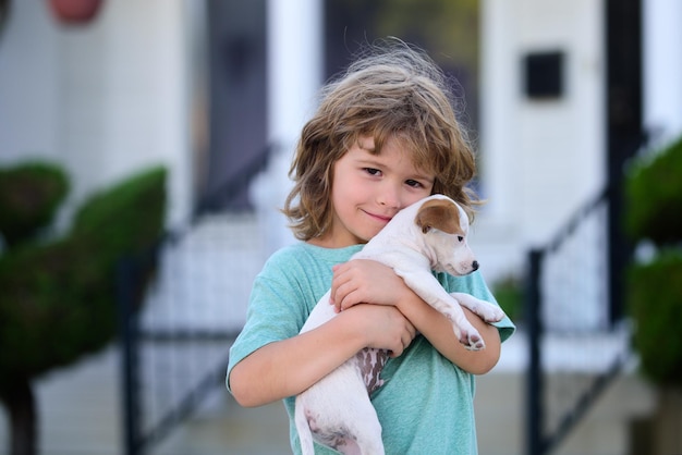 Cute child and dog hugs her with tenderness smiling Portrait kid boy with pet