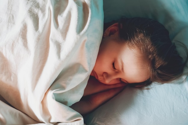 Cute child little girl sleeps in the bed