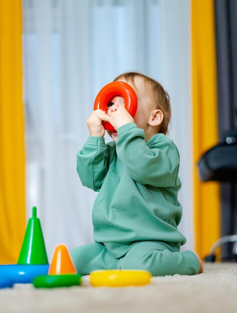 Cute child playing with color toy indoor Baby playing with pyramid toy Early development concept