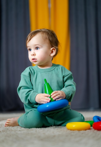 Cute child playing with color toy indoor Baby playing with pyramid toy Early development concept