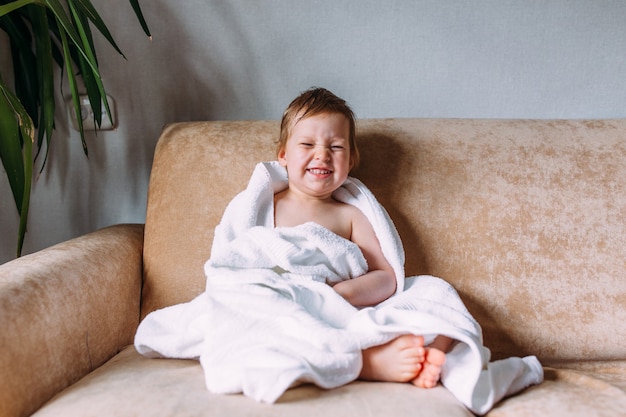 Cute child with blue eyes wrapped in a white towel