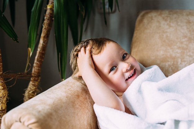 Cute child with blue eyes wrapped in a white towel