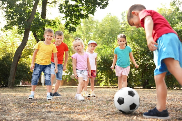 Cute children playing with ball in park