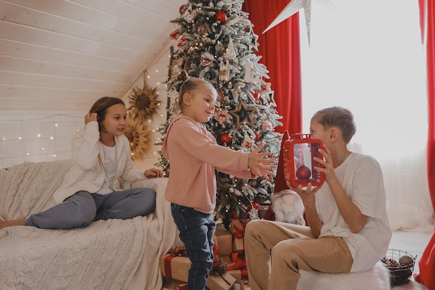 Cute children wrapping Christmas presents, closeup. Gift wrapping. Family, winter holidays and people concept