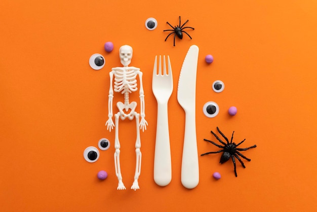 Cute childrens halloween party background with cutlery skeleton spiders and eyeballs