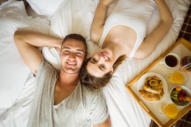 Cute couple having breakfast in bed