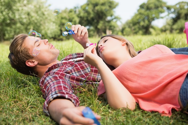 Cute couple in the park blowing bubbles