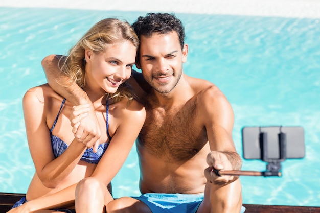 Cute couple taking selfie by the pool