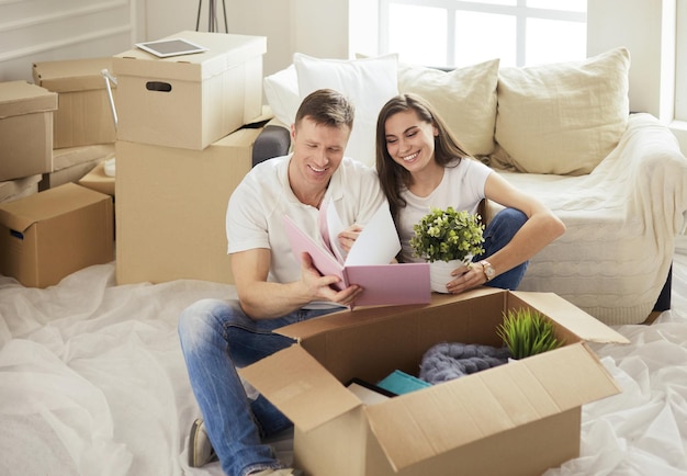 Cute couple unpacking cardboard boxes in their new home