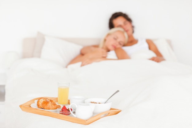 Cute couple with the breakfast put on a tray