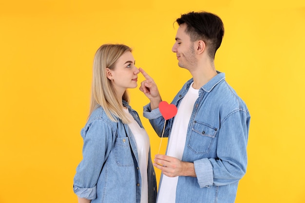 Cute couple with heart on yellow background