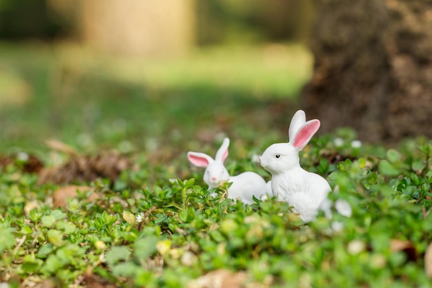 Cute easter bunny figurine on a green moss of the forest spring seasonal easter holiday background