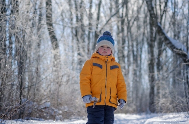 Cute European boy on a walk on a Sunny winter day