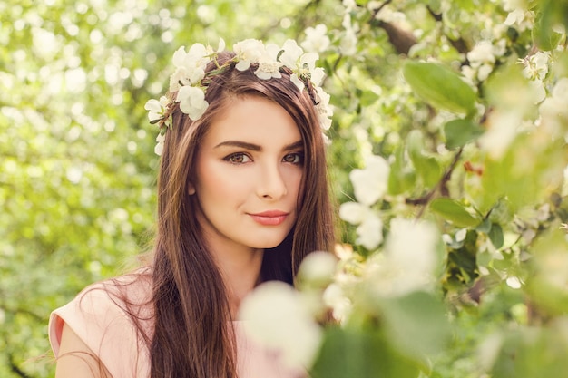 Cute female face closeup portrait Perfect young woman with brown hair makeup and spring flowers