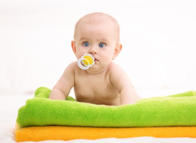 Cute funny baby lying on towels at home