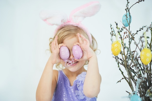 Cute funny girl with Easter eggs at home