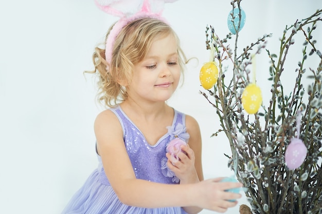 Cute funny girl with Easter eggs at home