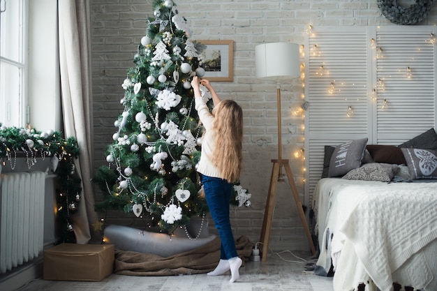 cute girl blonde hair decorating big christmas tree