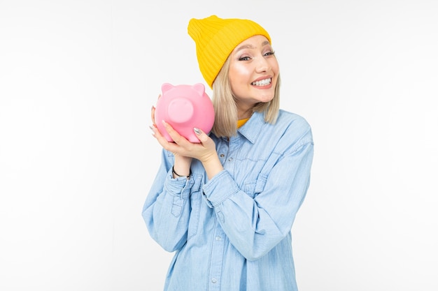 Cute girl in a blue shirt with a bank for saving money copy space