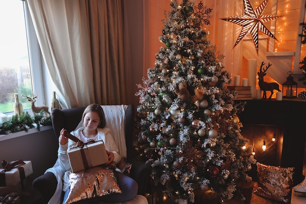 Cute girl decorates a Christmas tree. Merry Christmas and New Year Holidays.