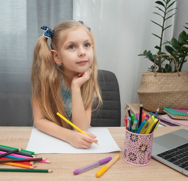 Cute girl doing homework in her room at home