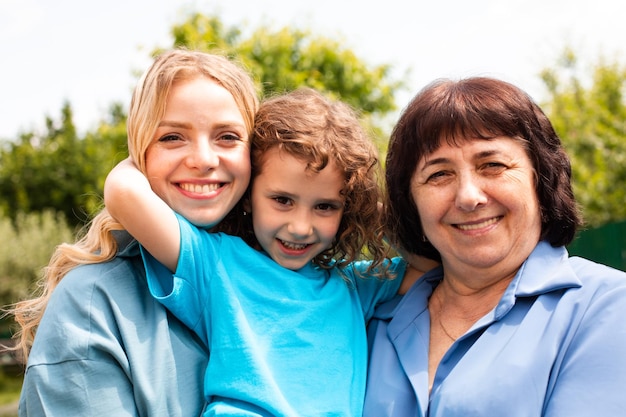 Cute girl embracing mother and grandmother outdoors