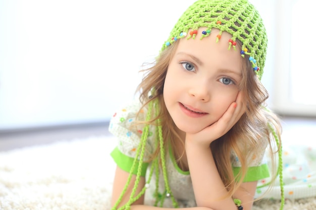 Cute girl green hat white carpet