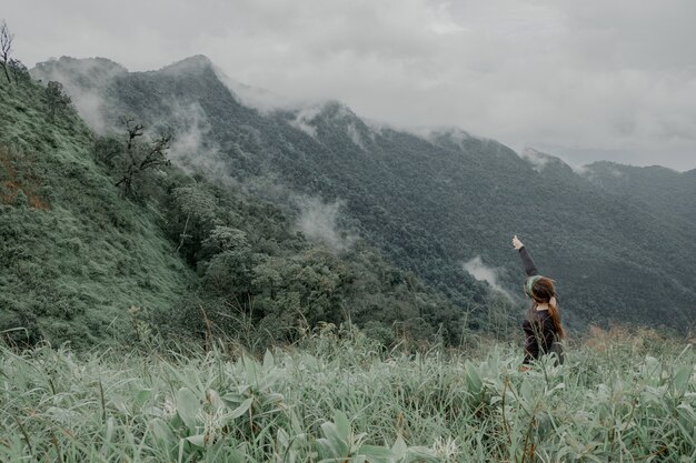 Cute girl hiking adventure on the high mountain with beautiful views of mist.