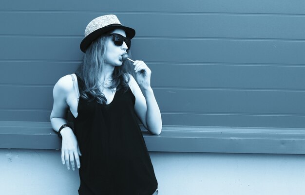 Cute girl hipster in light hat and sunglasses on a summer day