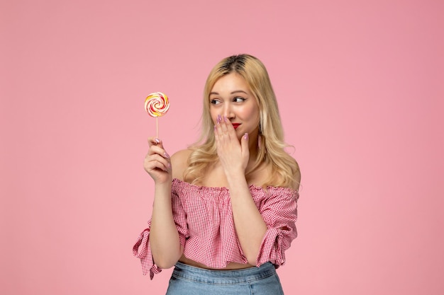 Cute girl lovely young lady with red lipstick in pink blouse so happy for a lollipop