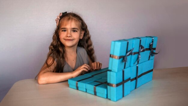 Cute girl near blue gift boxes formed like laptop