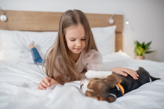 A cute girl playing with her puppy and looking happy