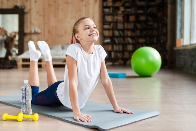 Cute girl practicing yoga on mat