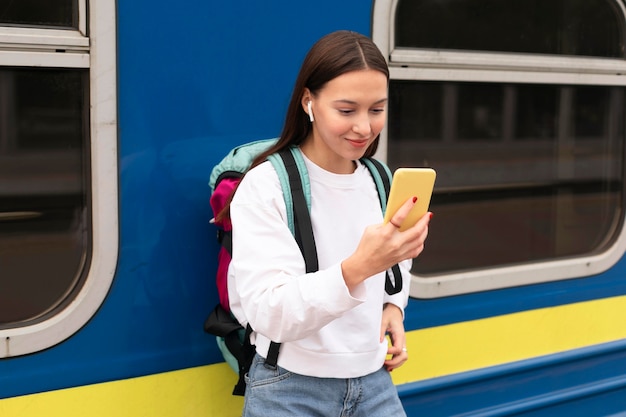 Cute girl at the railway station using mobile phone