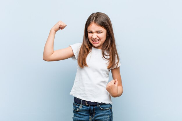 Cute girl raising fist after a victory, winner concept.