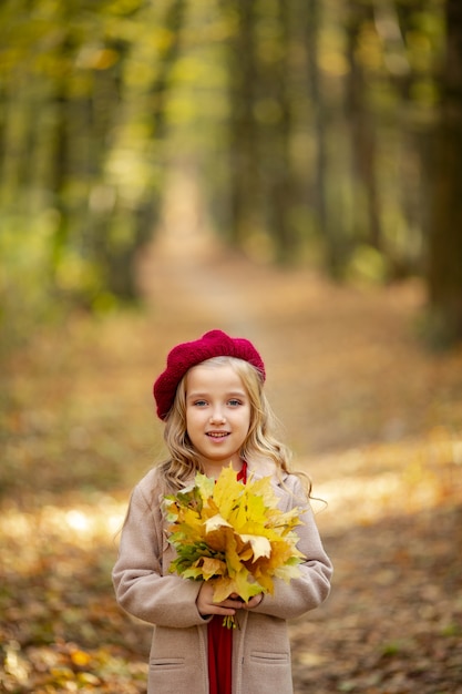 Cute girl in red beret on a walk in the fall