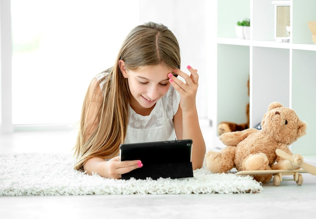 Cute girl relaxing watching tablet computer