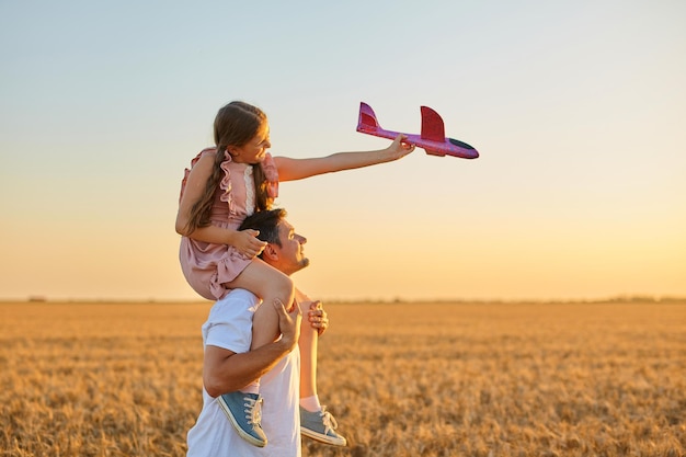 Cute girl riding on father's shoulder