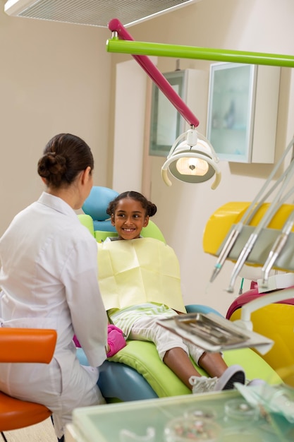 Cute girl sitting in front of a dentist