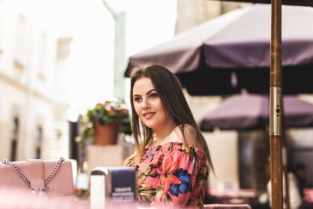 Cute girl sitting at a table in the street