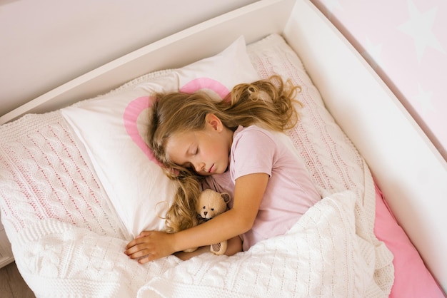 Cute girl soft toys sleeping peacefully in cozy bed