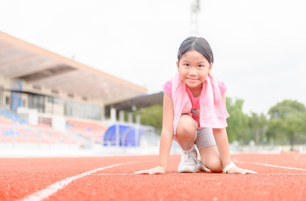 Cute girl in starting position ready for running.