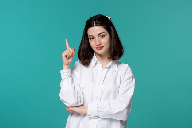 Cute girl young pretty adorable brunette girl in white shirt pointing up and thinking