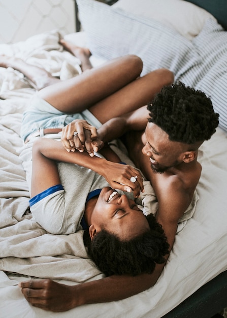 Cute happy black couple playing in bed