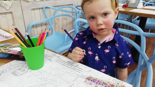 Cute happy little boy adorable preschooler painting in a sunny art studio Young artist at work