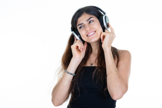 Cute happy pretty woman listening to music in headphones on white background