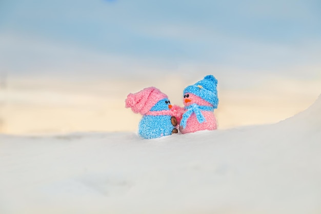 Cute homemade snowmen with scarves and hats on the mountain. Winter's Tale. Greeting card with copy space. Winter background.